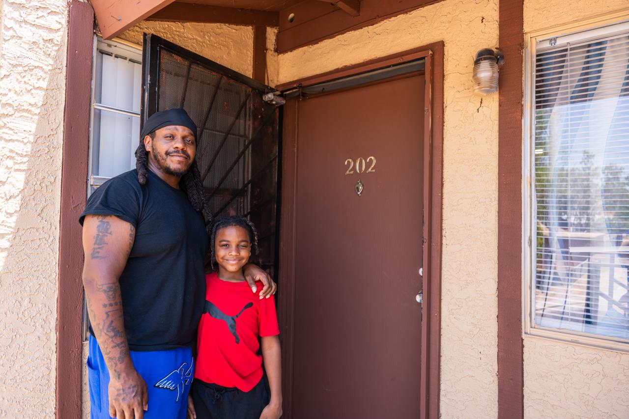 Quentin and his son outside their home