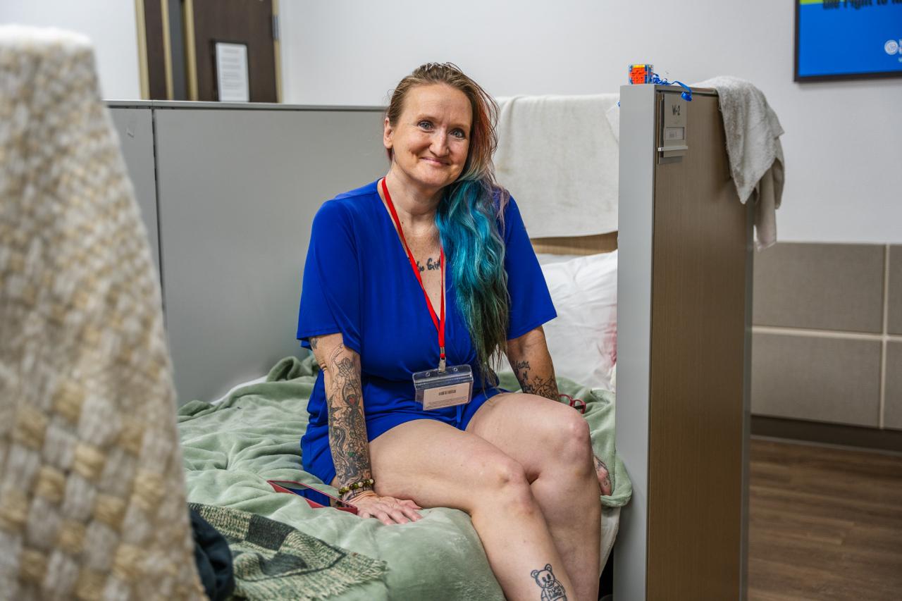 Alinda Nelson sits on her bed in Rosalie's Place.