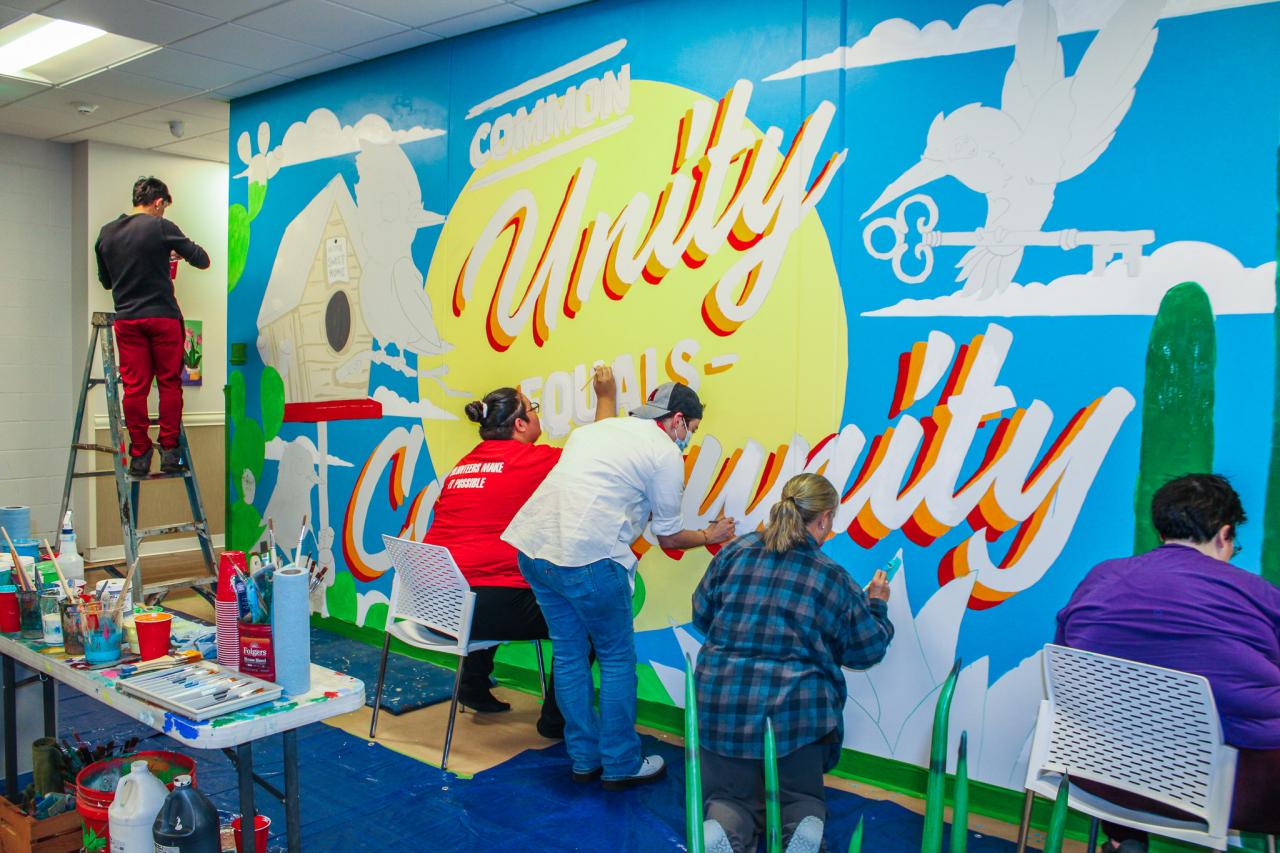 A group of residents and staff help paint the mural.