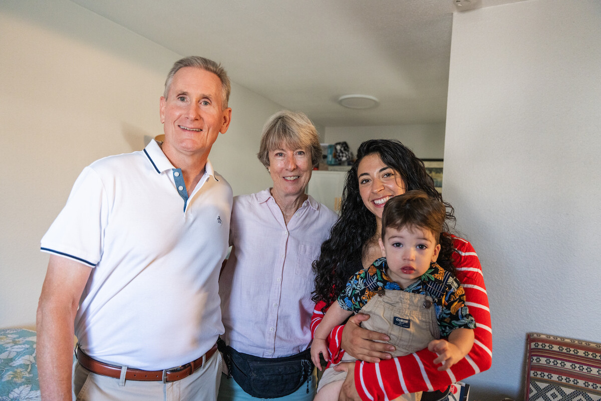 Vincentian volunteers Patrick Leahy (at left) and Julie Douglas (center) visit Lauren and Luka to drop off a food box and check in on the young mother and son.