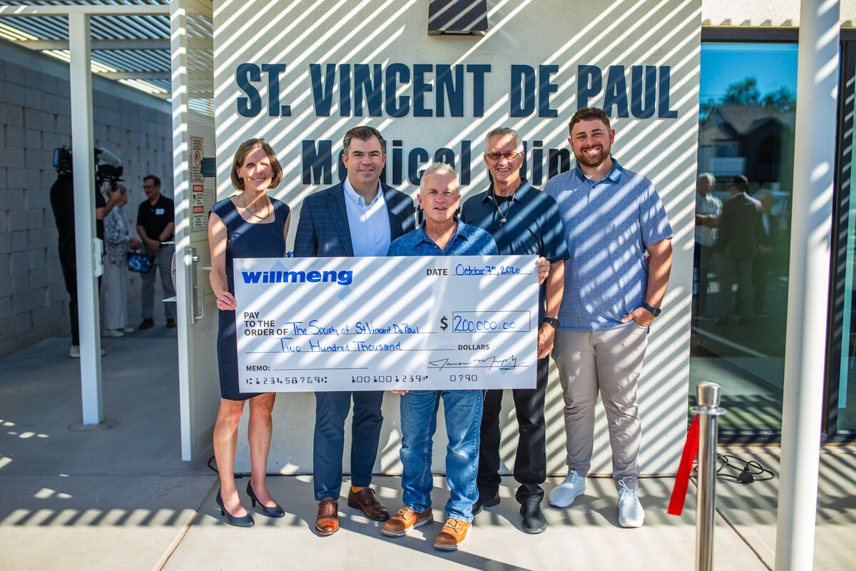 SVdP CEO Shannon Clancy (at left) accompanied by other SVdP and Willmeng employees receives the $200,000 check presented by Willmeng Senior Vice President Chris Brown (second left) to help support the care of the clinic's first patients. (Photo by SVdP's Noah Hedlund)