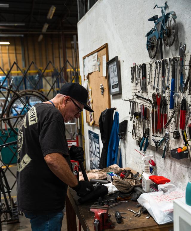 Ricky works at a desk with bike equipment.