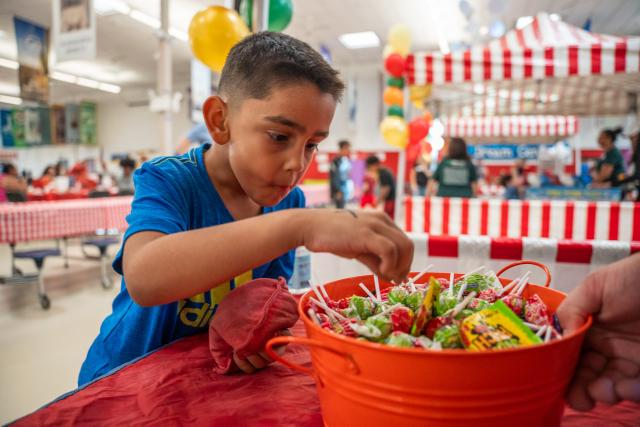 A young boy picks a piece of candy as a prize at the carnival at SVdP's Family Evening Meal.