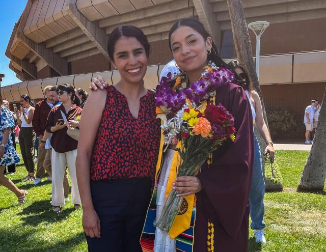 Diana poses in her graduation gown with Alejandra, her mentor, after her graduation ceremony.